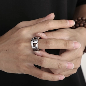 Detail of vintage silver chain ring with hollow portrait design on male model