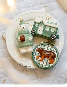 Detailed view of polar bear and camper van Christmas ornaments on white embossed ceramic tray
