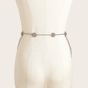 Mehrlagige silberne Metall-Taillenkette mit 3D-Blumenakzenten für Damen am beigen Mannequin