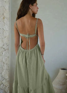Détail d'une robe longue verte dos nu avec lacets et tissu en lin à volants