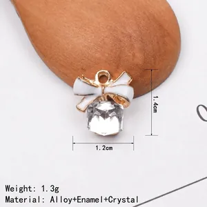 Detail of DIY bow charm with white enamel and square crystal pendant in gold alloy