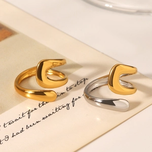 Macro detail of polished two-tone open rings on vintage paper with minimalist aesthetic