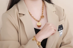 Close-up of a gold stainless steel smile necklace and bracelet set with T-bar closures