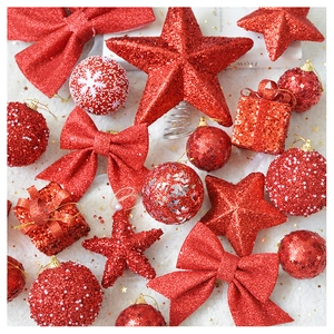 Close-up of red glitter Christmas ornaments including stars, bows and gift boxes on snow