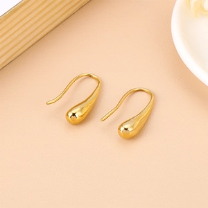 Detail of gold teardrop earrings with polished finish and elegant curved hooks