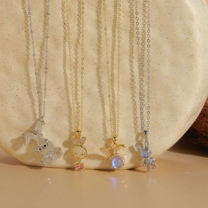 Close-up of gold and silver rabbit pendants with enamel and sparkling crystal inlay
