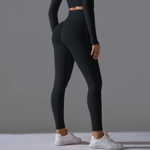 Detail showing high-waist seamless black yoga pants with peach butt lifting scrunch