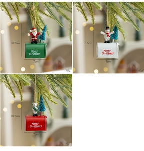 Detail of Christmas mailbox ornaments with snowman and Santa hanging on a pine tree