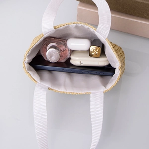 Straw mini handbag in beige with white handles showing interior storage space for essentials