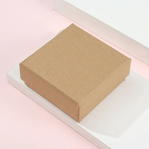 Detail of square kraft paper jewelry box with lid on light pink background