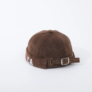 Macro view of brown corduroy kids brimless hat with CA embroidery and metal buckle