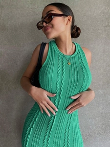 Detalle del tejido de punto trenzado verde y corte entallado del vestido sin mangas