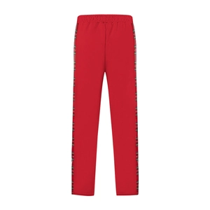 Detail of red joggers featuring side plaid ribbon trim and elastic waist for sporty style