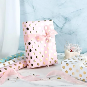 Colorful dot wrapping paper in pink, blue and white with gold foil dots for gift packaging
