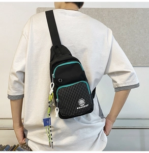 Detail of water-resistant black chest bag featuring grid patterns and blue zippers