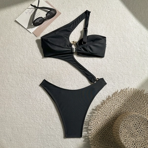 Detail view of black one-shoulder swimsuit with waist cutout and gold metal ring