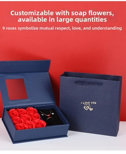 Blue jewelry gift box with red roses and heart necklace shown in a handheld gift bag