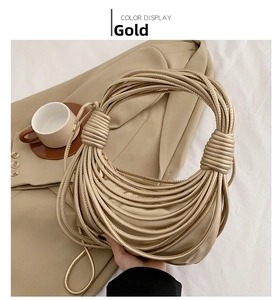 Macro detail of a golden knotted noodle shoulder bag with luxury woven texture finish