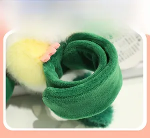 Close-up of fluffy parrot plush wristband showing fine stitching and soft green fabric