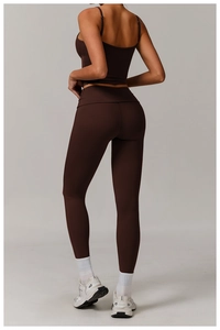 Detail view of the deep brown sports bra and high-waisted yoga leggings on a model