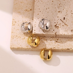 Minimalist teardrop huggie earrings in polished gold and silver finishes on stone