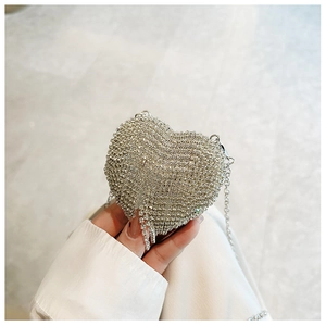 Close-up of heart-shaped evening bag with silver rhinestones and metal chain strap