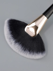 Close-up of dual-tone soft fan brush with champagne gold ferrule and black handle