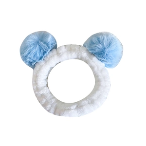 White plush headband with large blue pom-poms for face washing and skincare routines