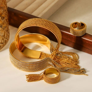 Detailed view of bicolor stainless steel tassel bracelets and beaded rings on stone