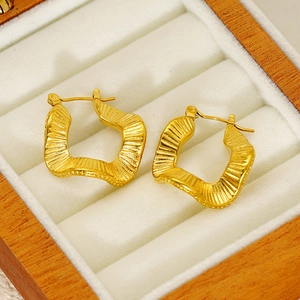 French vintage golden hoop earrings with pleated texture on white velvet cushion