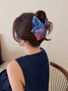 Détail d'une élégante pince à cheveux bleue à motif tie-dye sur un chignon de femme