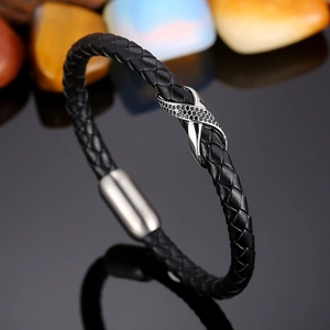 Close-up of infinity symbol charm with black zircon on braided leather bracelet