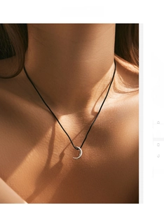 Detail of s925 silver crescent moon pendant on a minimalist black cord necklace