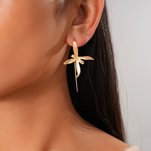 Close-up of a model wearing the golden metallic iris flower drop earring in a soft light