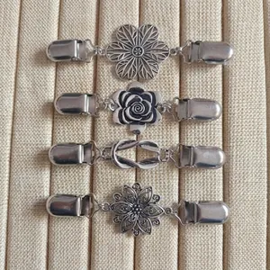 Vue détaillée de clips de cape en argent avec placage épais et motifs floraux variés
