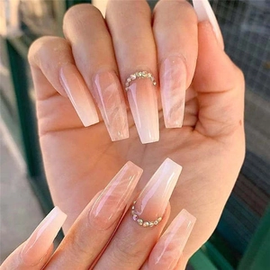 Detail of nude pink marble gradient coffin nails with rhinestone accent on fingers