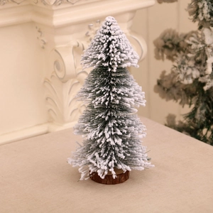 Close-up of a snow-sprayed mini pine tree with a wooden base for table decoration