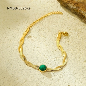 Macro shot of twisted gold snake chain bracelet with green malachite gemstone inlay