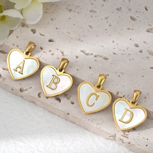 Golden heart-shaped letter pendants with white mother of pearl inlay on stone