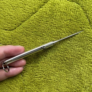 Dettaglio dello stuzzicadenti portatile in titanio con molla a scomparsa e portachiavi