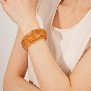 Close-up of amber acrylic geometric stretch bracelet worn on a model's wrist
