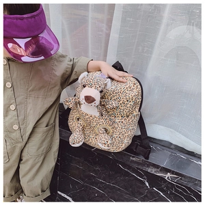 Detail of yellow leopard print toddler backpack with cute plush animal toy in front pocket