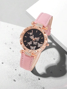 Detail of rose gold butterfly watch with pink leather strap and rhinestone dial accents