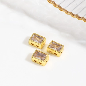 Gold-plated rectangular spacer beads with zircon inlays on a clean white background