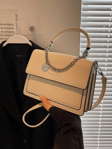Chic beige crossbody square bag with silver chain and marble tag in natural light