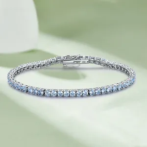 Detailed close-up of a sterling silver tennis bracelet featuring round blue gemstones