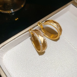 Dettaglio degli orecchini a C placcati oro 18k con pavé di zirconi in un portagioie