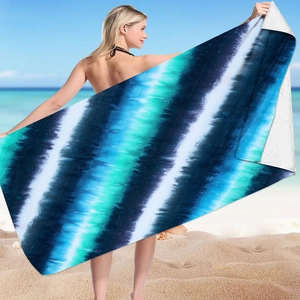 Tie-dye microfiber beach towel held by model showing striped blue and green pattern detail