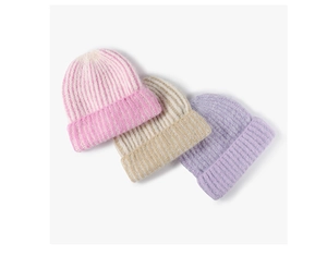 Detail view of winter knitted beanies in pink, beige, and lilac with ribbed texture
