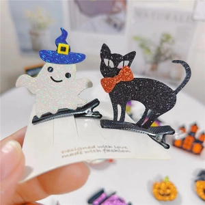 Dettaglio di fermagli per capelli Halloween con fantasma bianco e gatto nero glitterati su metallo